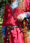 Our Versatile Baldric in Chestnut Leather shown from the side with sword hanging vertically.