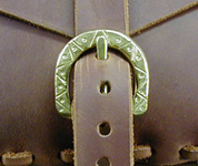 Hand-decorated brass buckle close-up.